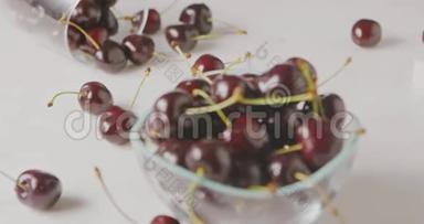 在一张白色桌子上的玻璃碗里，用一个成熟的红樱桃做一个全景式的慢动作特写，背景模糊